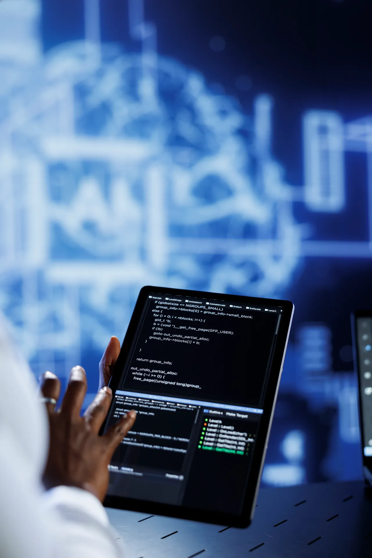Tablet displaying software code in a technology workspace