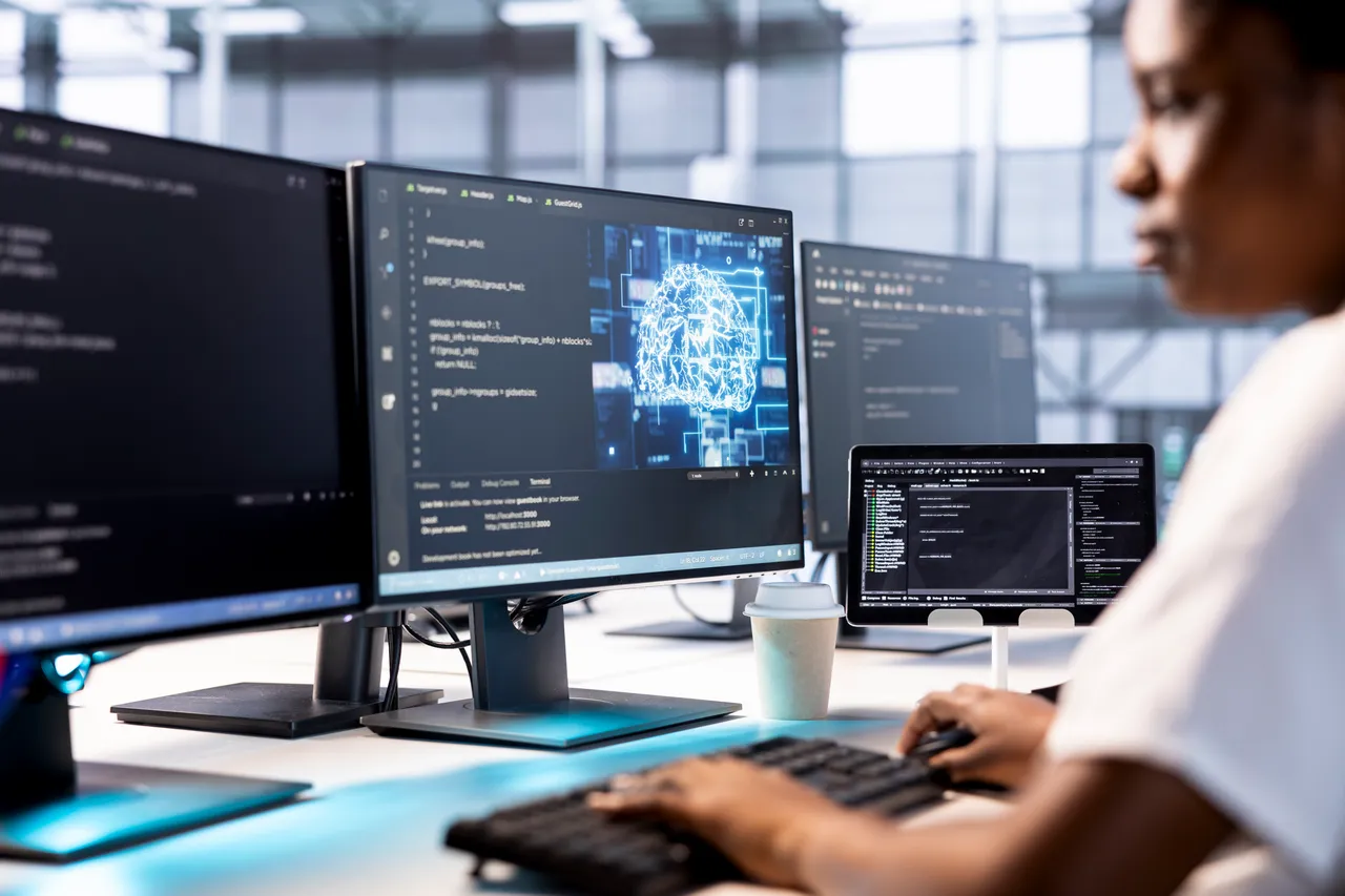 Developer working with code and system monitoring screens